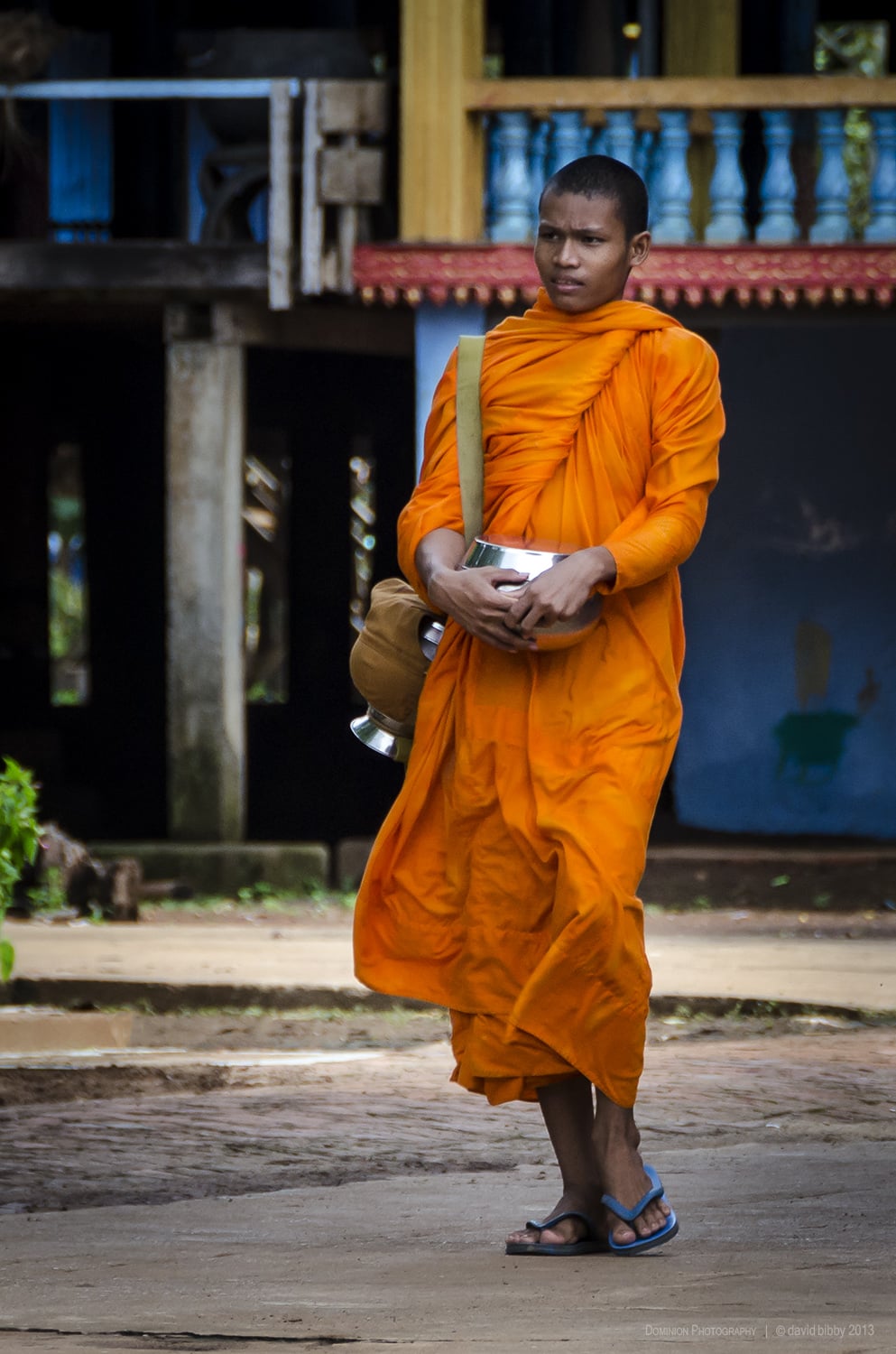   Young monk  - A Buddhist monk prepares for the morning alms round. Wat Hanchey, Cambodia. 