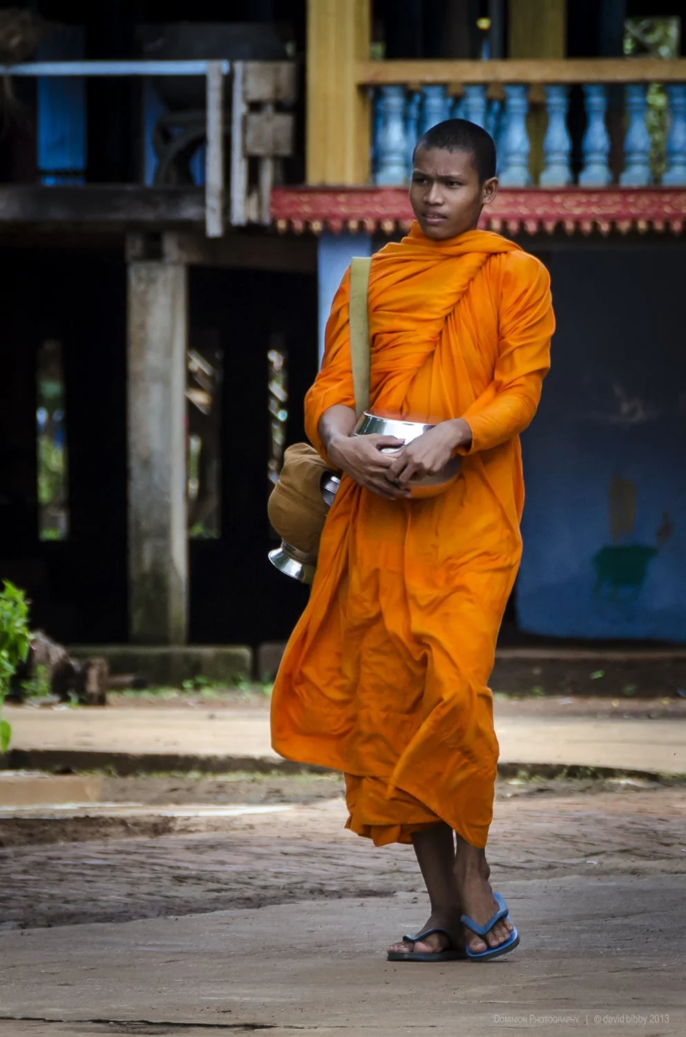 Young monk - A Buddhist monk prepares for the morning alms round. Wat Hanchey, Cambodia.