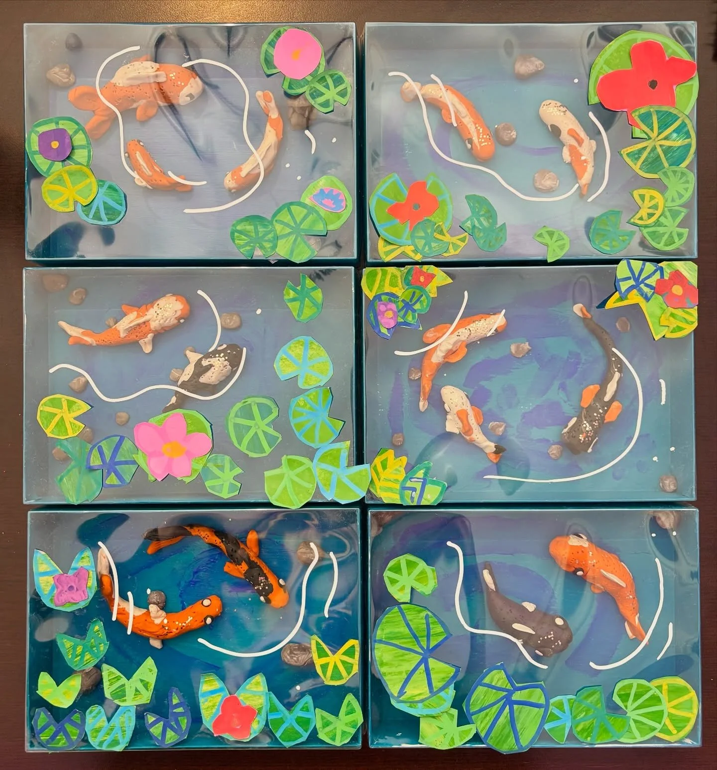 Today our Grade 1-3 #ArtExplorations class had fun making #koipond shadowboxes. For this project, we used painted paper collage to make lily pads on the lid of our boxes. We then used #plasticine to sculpt koi fish and pebbles to add to the bottom of