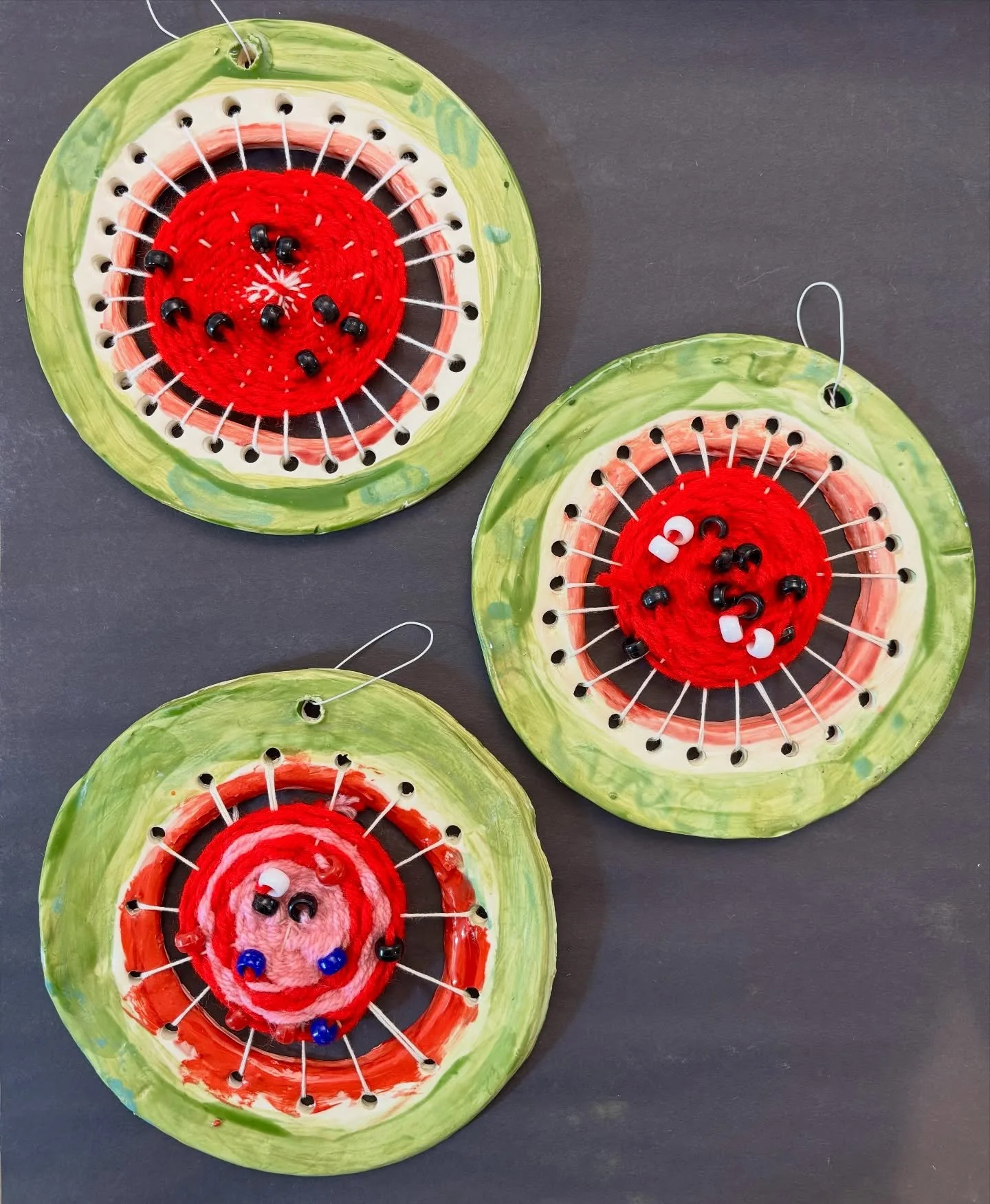 These #watermelonlooms were made by our Wednesday Grade 1-3 #artexplorations class. For this project, we used ceramic clay and coloured glazes to sculpt and paint a watermelon themed circular loom. We then learned how to weave our looms using waterme