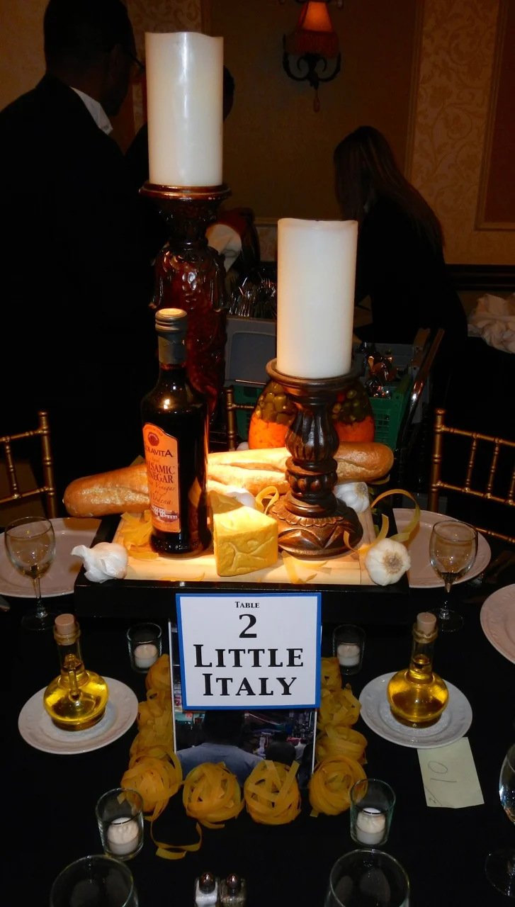 For our Little Italy centerpiece, we featured carved wood candle holders, an assortment of preserved and prop foods, fresh pasta, and images of Little Italy. We even included Egil's favorite: lots of fresh garlic.