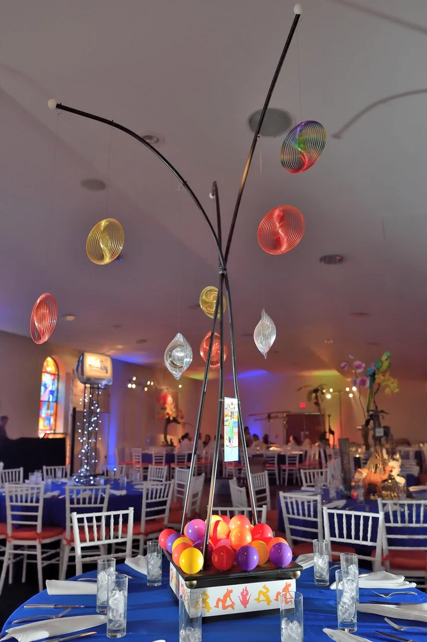 Small, moving sculptural elements with graphics for a gymnastics themed centerpiece