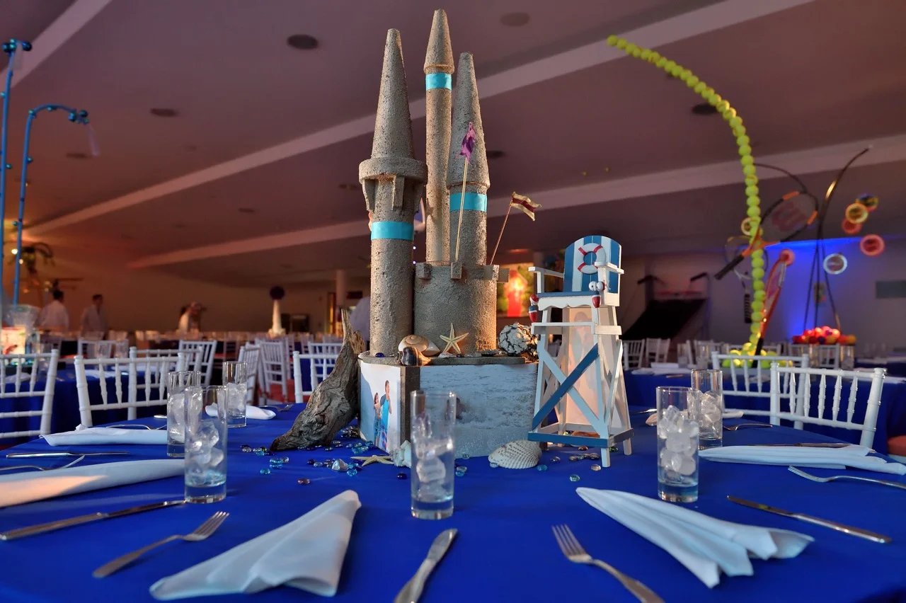 A sand castle, driftwood, family beach photos, and decorative accents for a beach theme centerpiece 