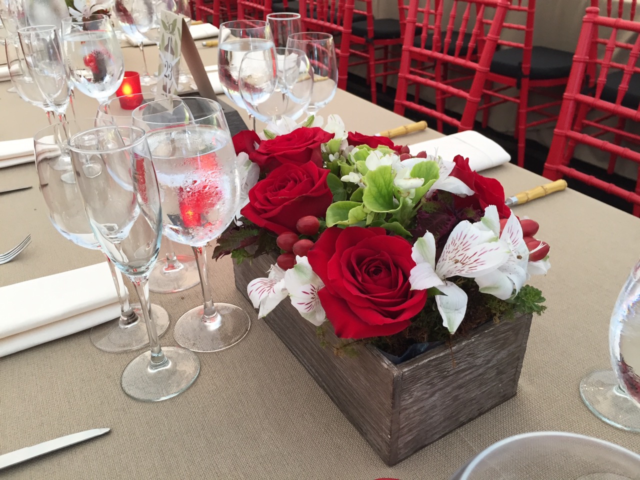 Rustic, garden box-inspired centerpieces with red roses, hypericum and live rooted floral accents