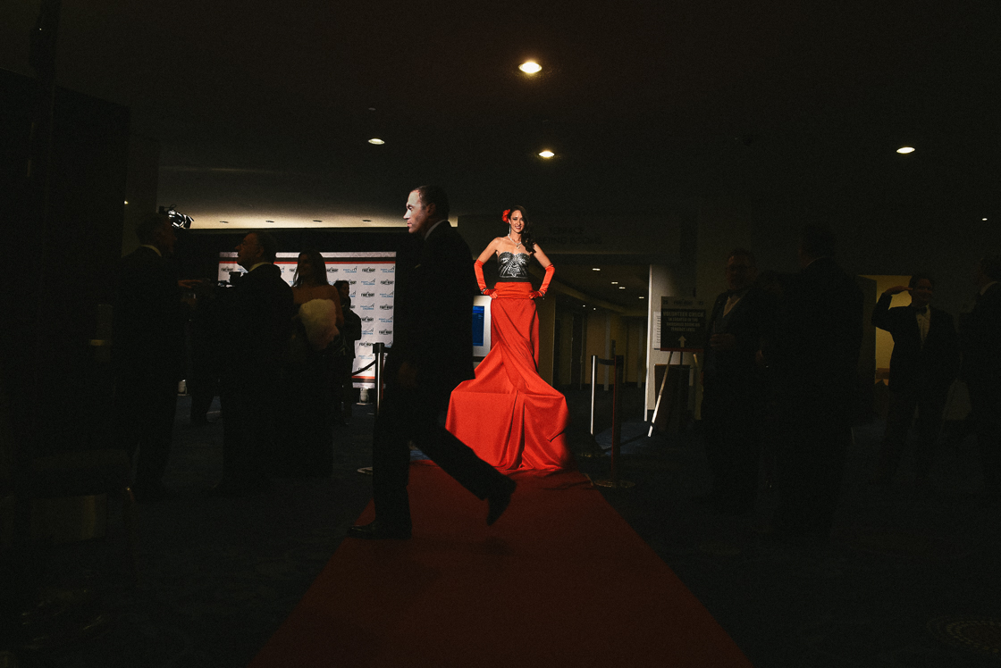 Guests makes their way into the grand ballroom past one of the women hired to pose in body paint on pedestals during the event.