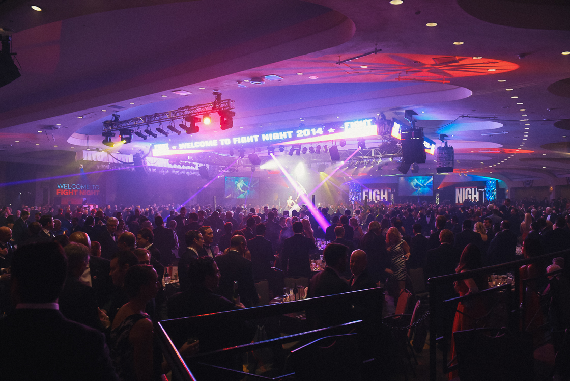 Tuxedo-clad men mill around the smoke-drenched Washington Hilton ballroom. 2,000 business leaders and government officials attend the annual fundraiser event, which raises millions for DC children's education and healthcare.