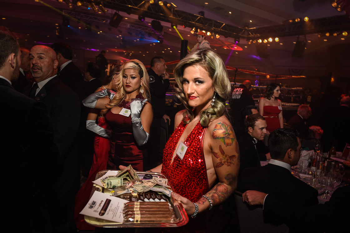 Cocktail waitress Dana Nelson takes a spin around the ringside sponsor tables with a tray of cash and cigars for sale to benefit Fight for Children.