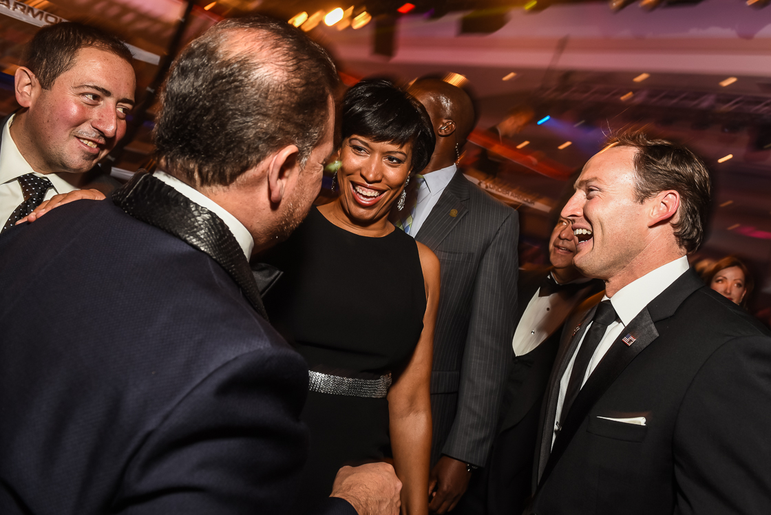 Mayor-elect Muriel Bowser laughs with male business leaders during pre-fight cocktails. 