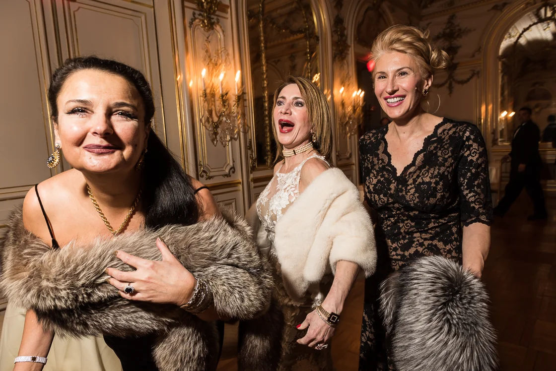Diplomatic Liaison Rhoda Septilici, left, clutches her fur as she laughs with her friends, Leila Beale, wife of the Barbados ambassador (center), and Gabriela Coman (right) at the Russian Ball. 