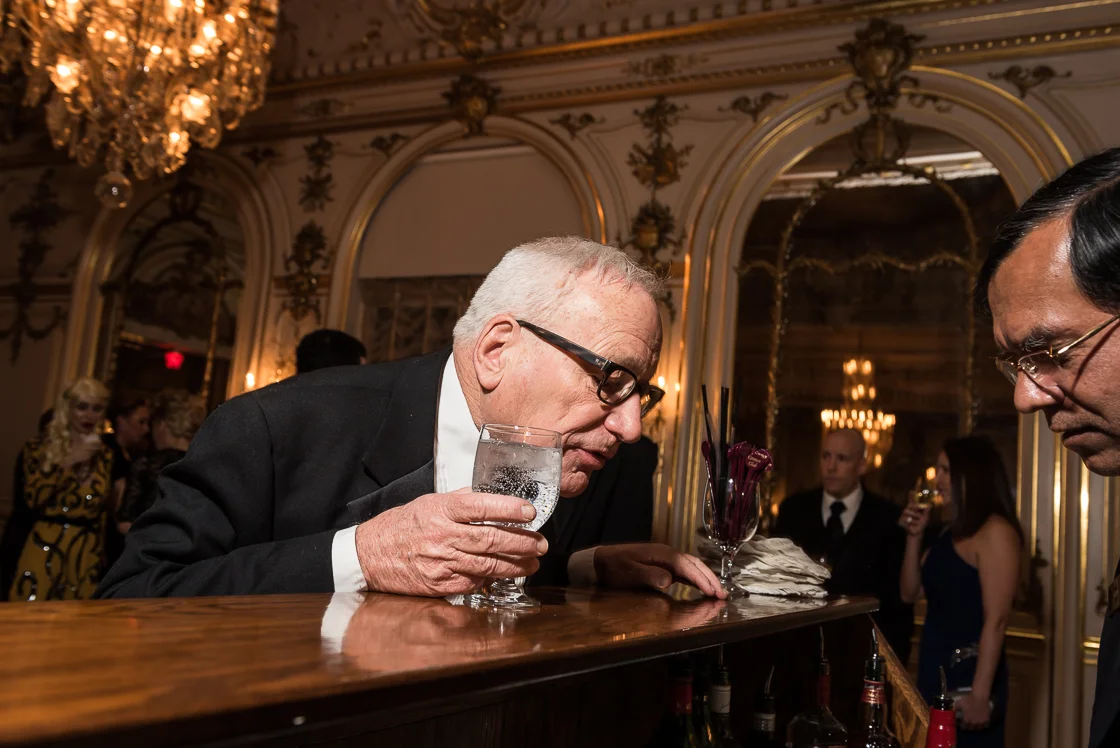 John Dick peers over the bar wondering about the status of his cocktail. 