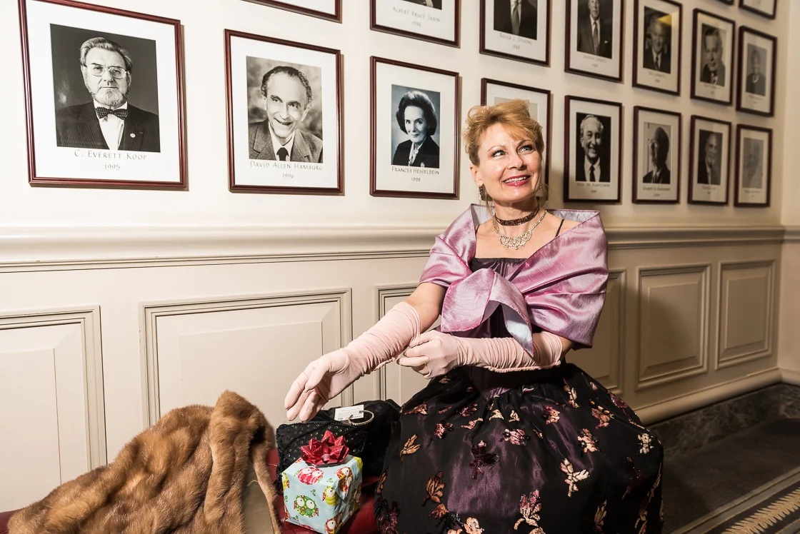 Mary Ellen Hood dons elbow-length gloves under the watchful eyes of previous members of one of Washington's private clubs, which hosted the annual Russian Ball. 