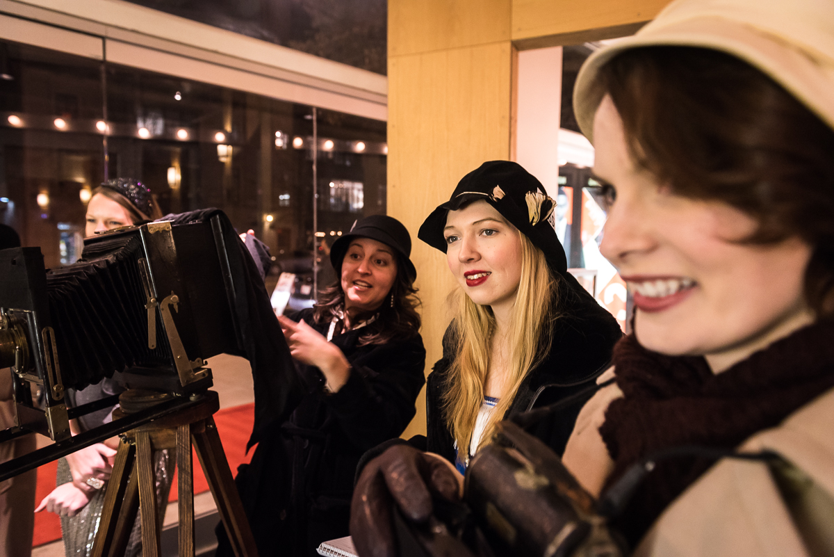 Volunteer actresses Lelia TahaBurt, Megan Konyndyk, and Jessica Inzeo (from left) perform as friendly paparazzi to guests as they arrive. 