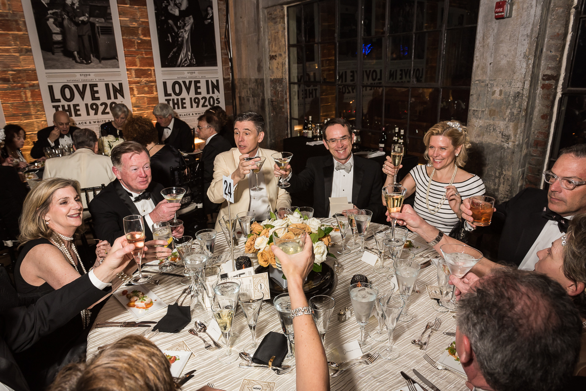 A table of Studio Theater Gala guests raise their glasses to cheers a successful event. 