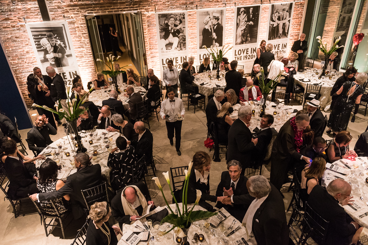 Guests gathered around simple and chic tables with white iris centerpieces for dinner