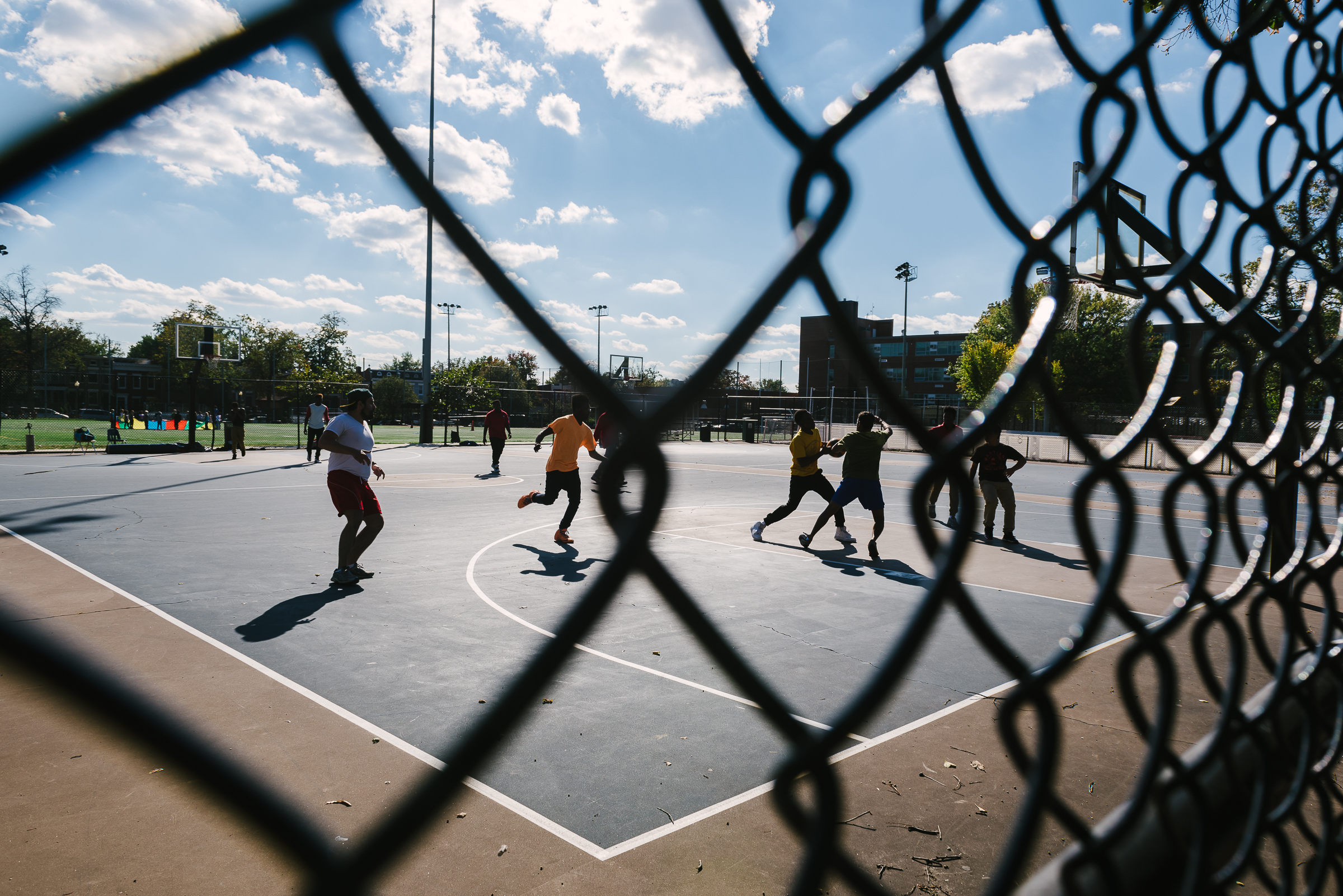Neighborhood resident play basketball on the courts built when the new school was built next door to the old one. Often, new buildings are constructed instead of preserving the old ones as a cost-cutting measure, leaving historic structures to rot in vacancy. 