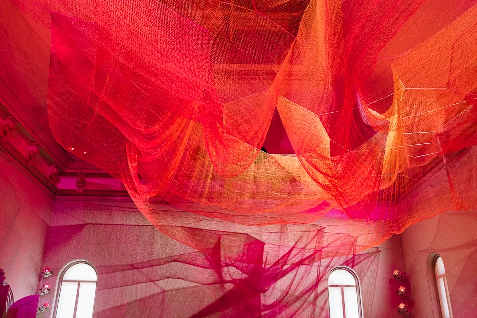 Janet Echelman's woven textile installation mirrors the affects of an earthquake through suspended nets and a corresponding carpet below.