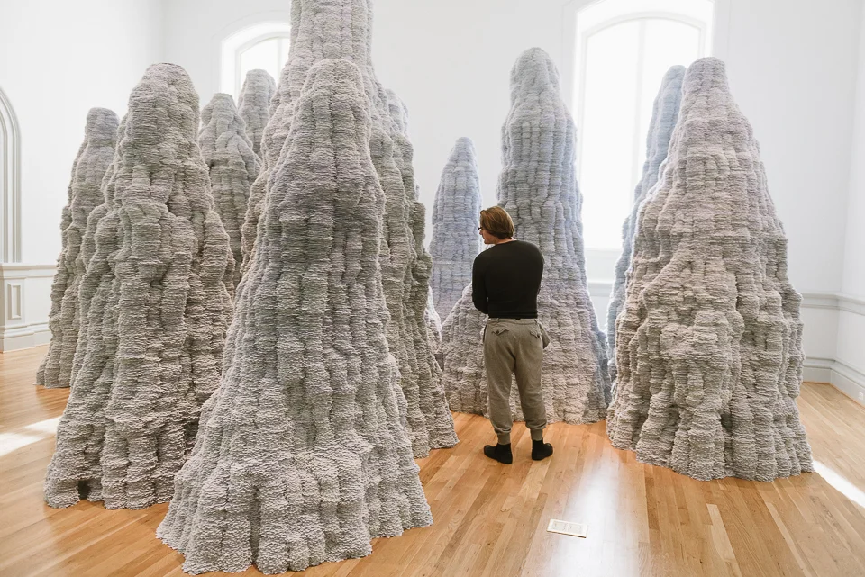 Martin stands among Tara Donovan's installation made of index cards. 