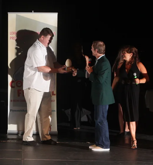 Getting presented with my Plymouth Rock Comedy Festival winning trophy