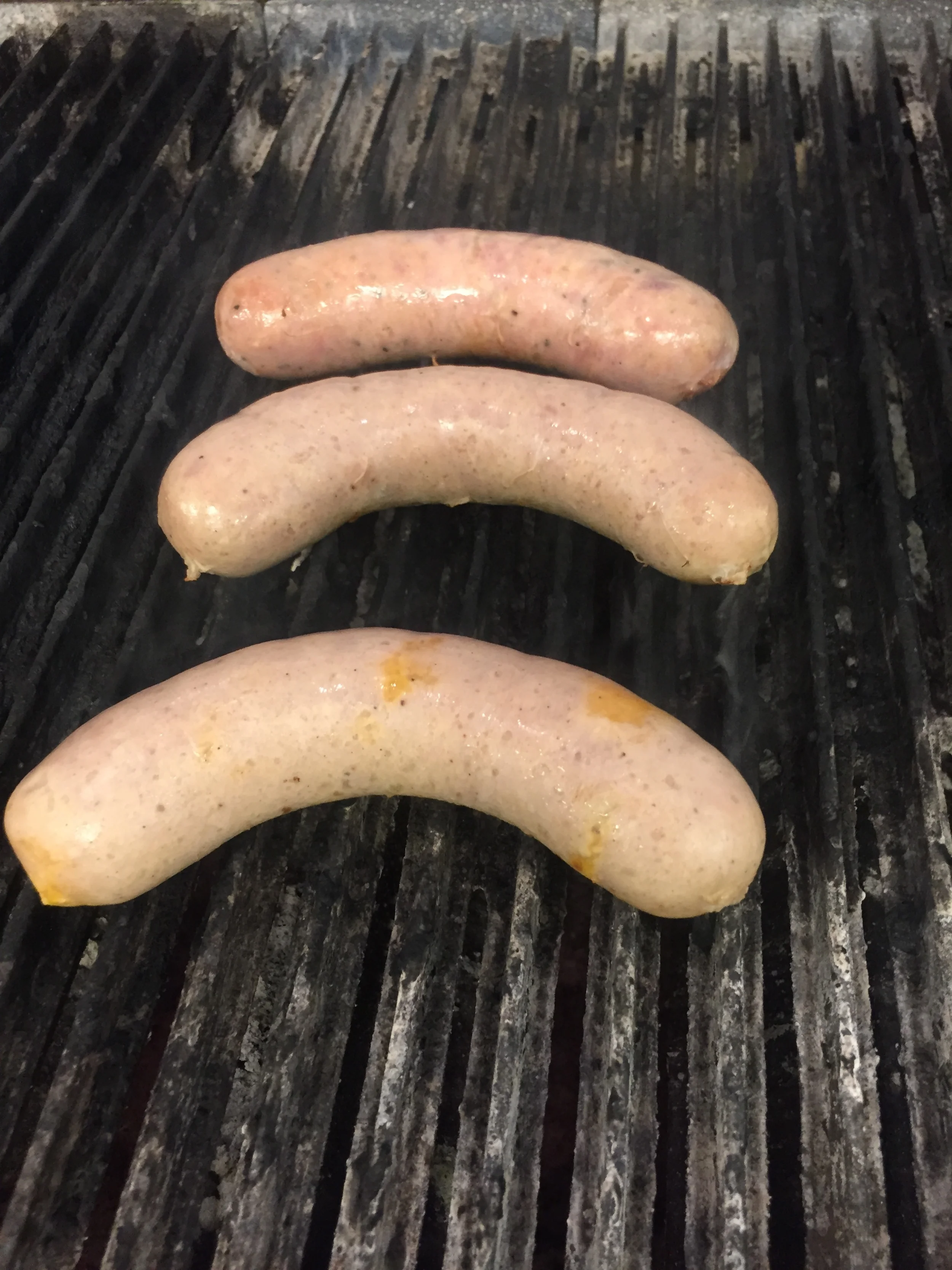 Fassler Hall's Jalapeño Cheddar Sausage and Hunter Sausage on the grill