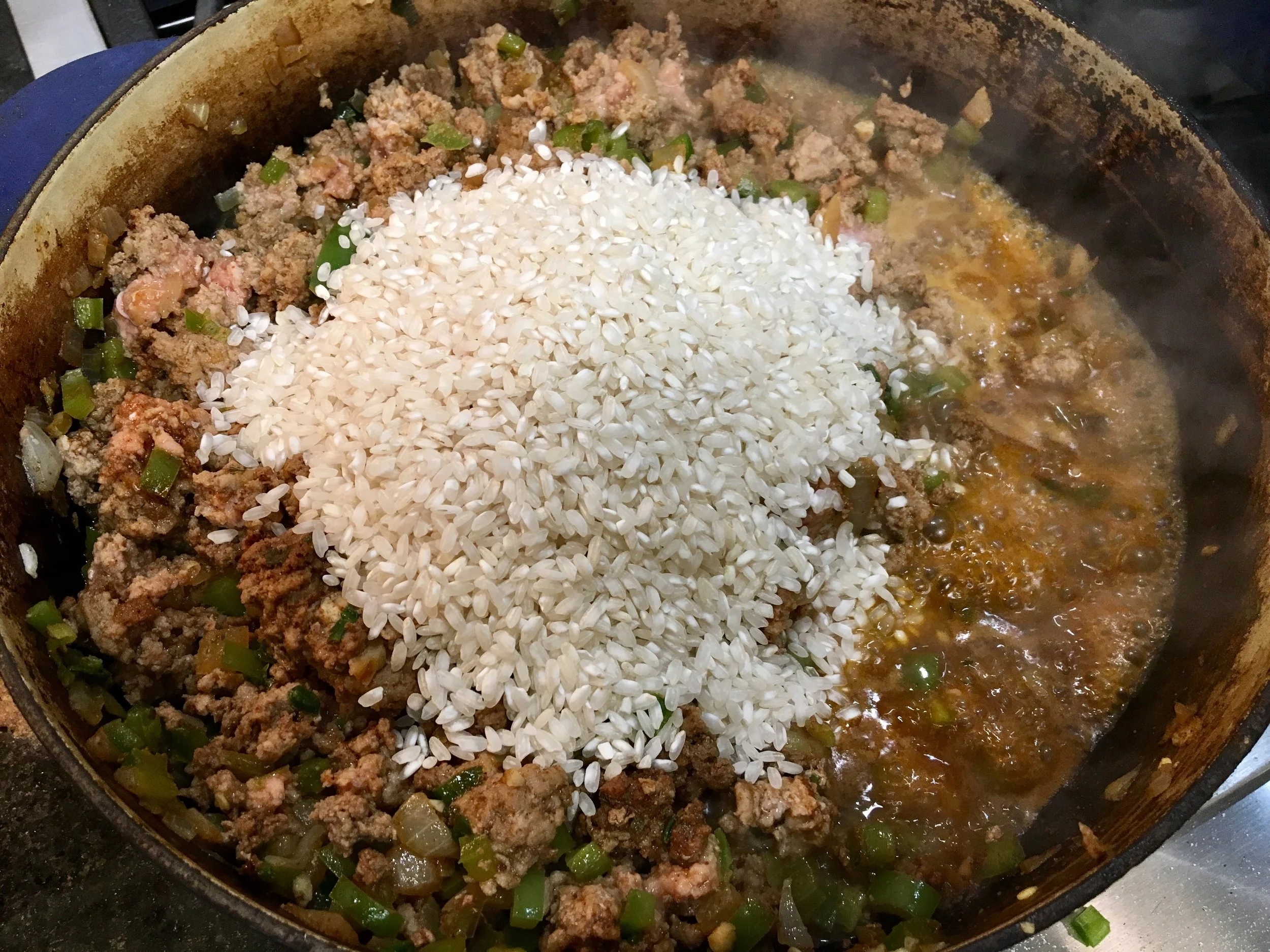 Add in the rice after the meat, onion, and peppers are cooked.