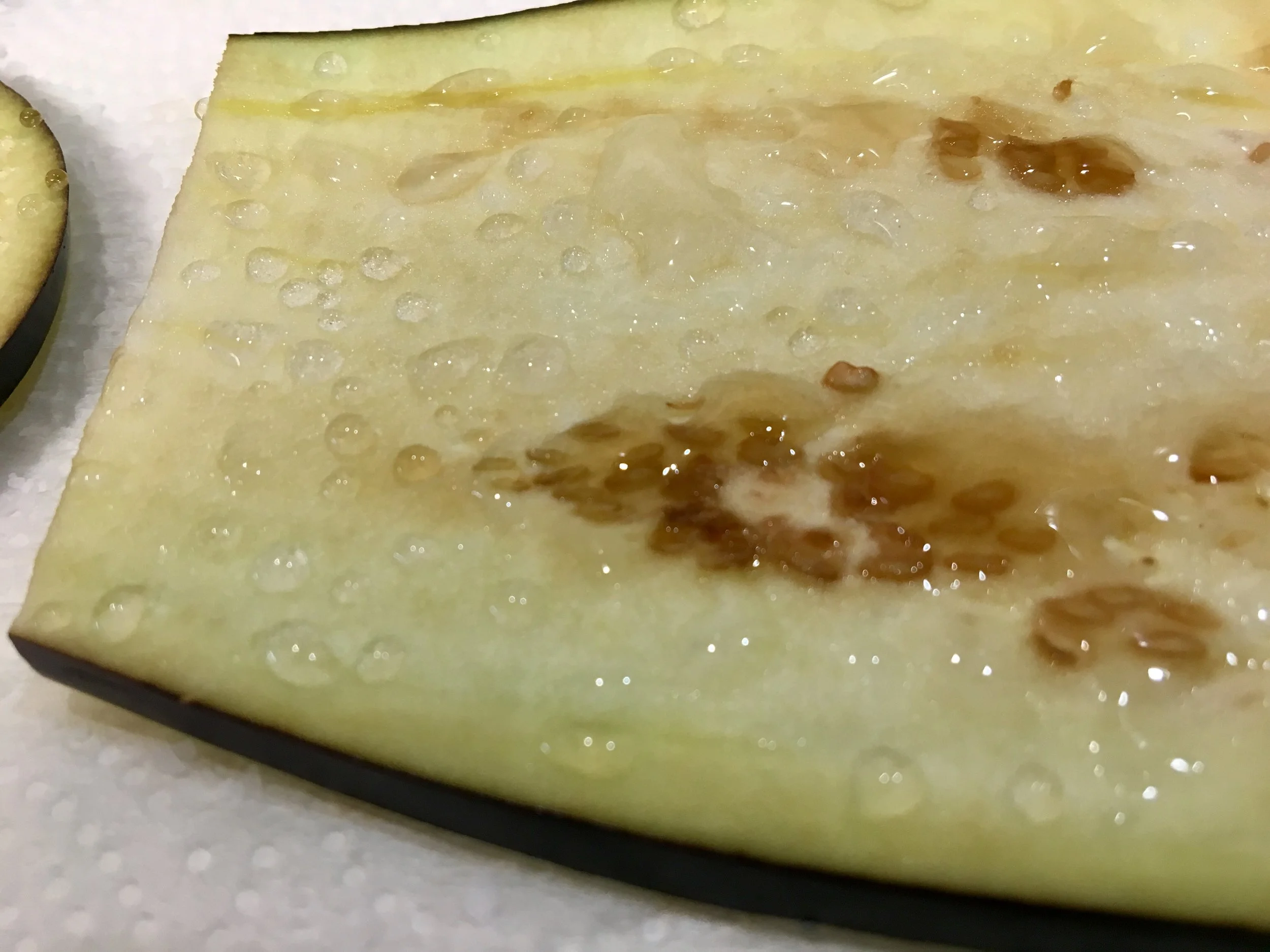 Excess water being removed from the sliced eggplant with the help of salt.