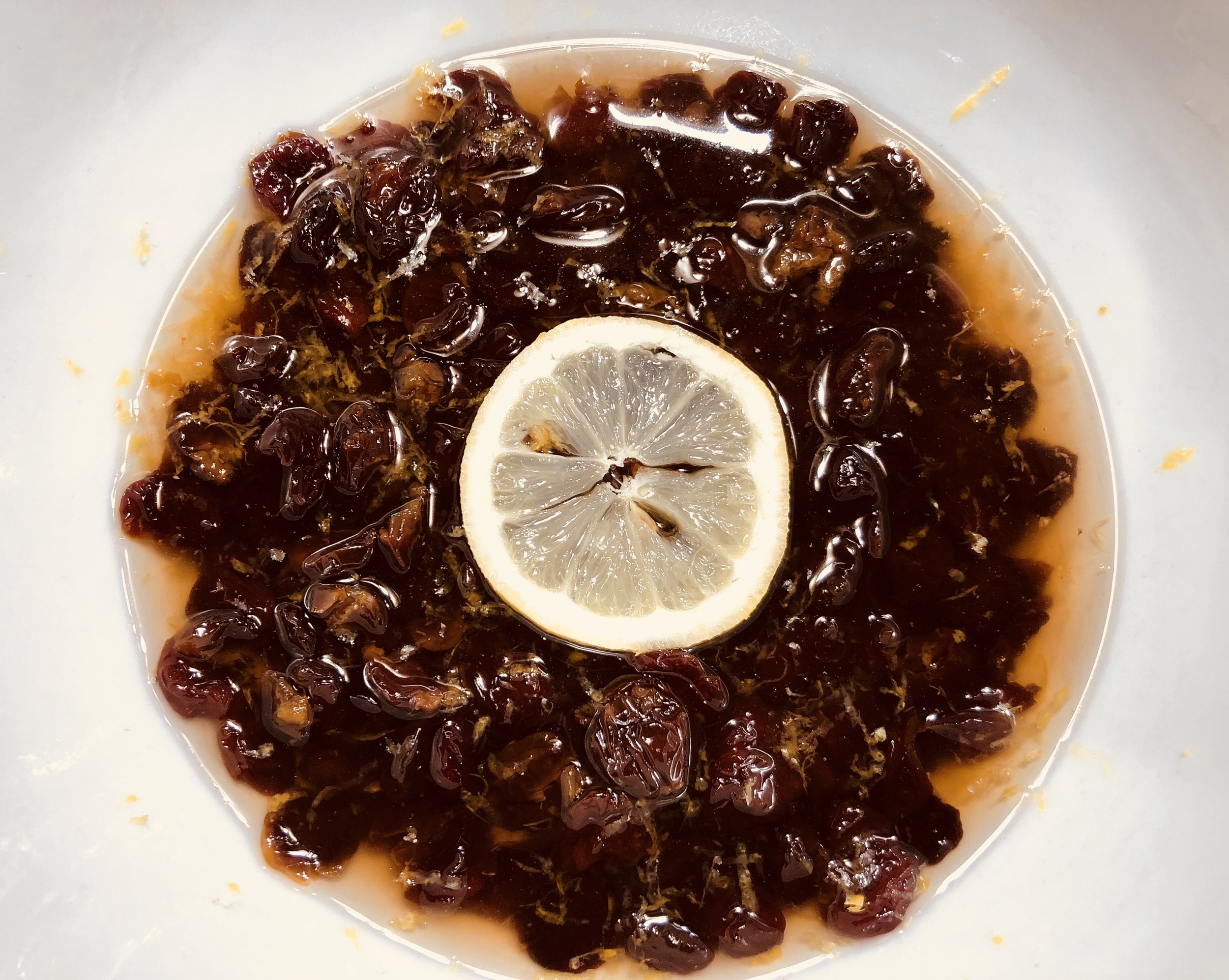 Marinating the dried cherries with lemon zest, vanilla, and sugar.