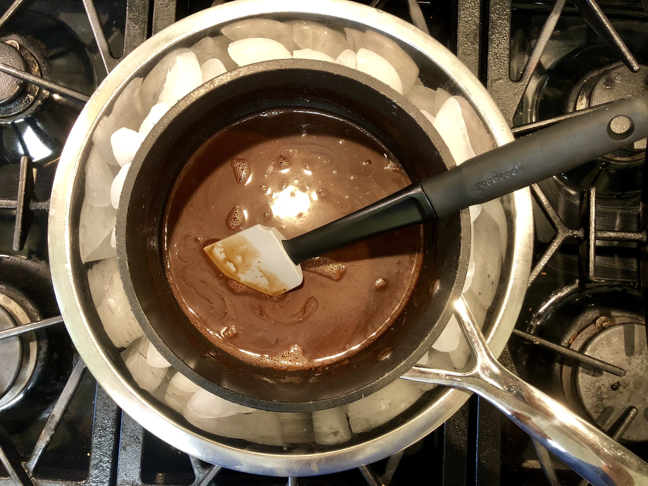 Cooling the mixture over ice before glazing the cake.