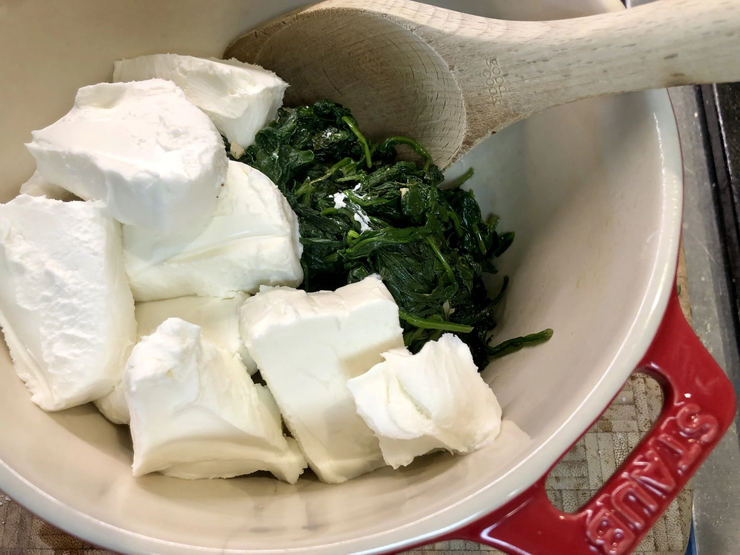 After sautéing the spinch and squeezing dry, add the Chèvre goat cheese and mix together.