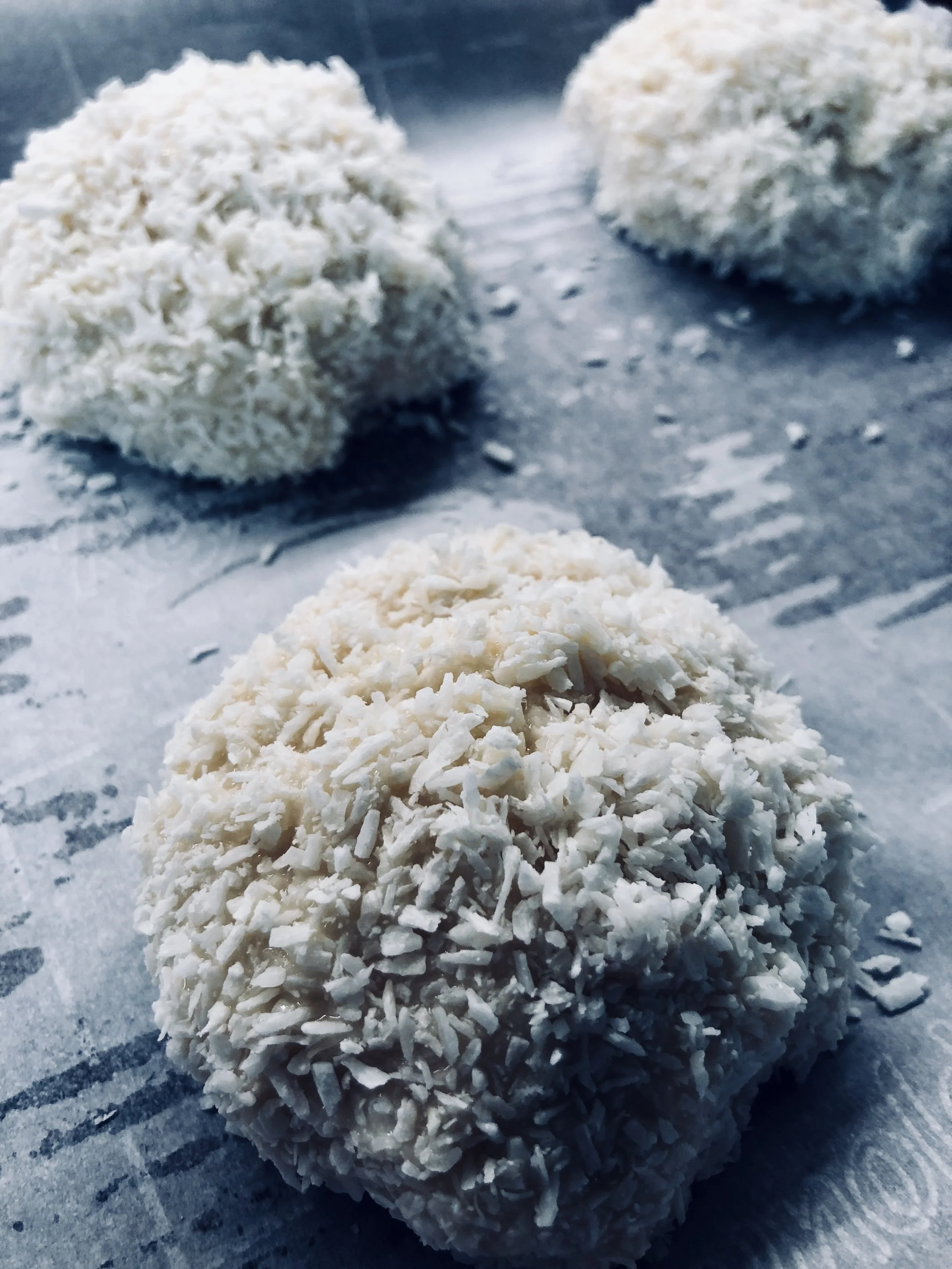 Macaroons are coated in extra coconut and ready for the oven.