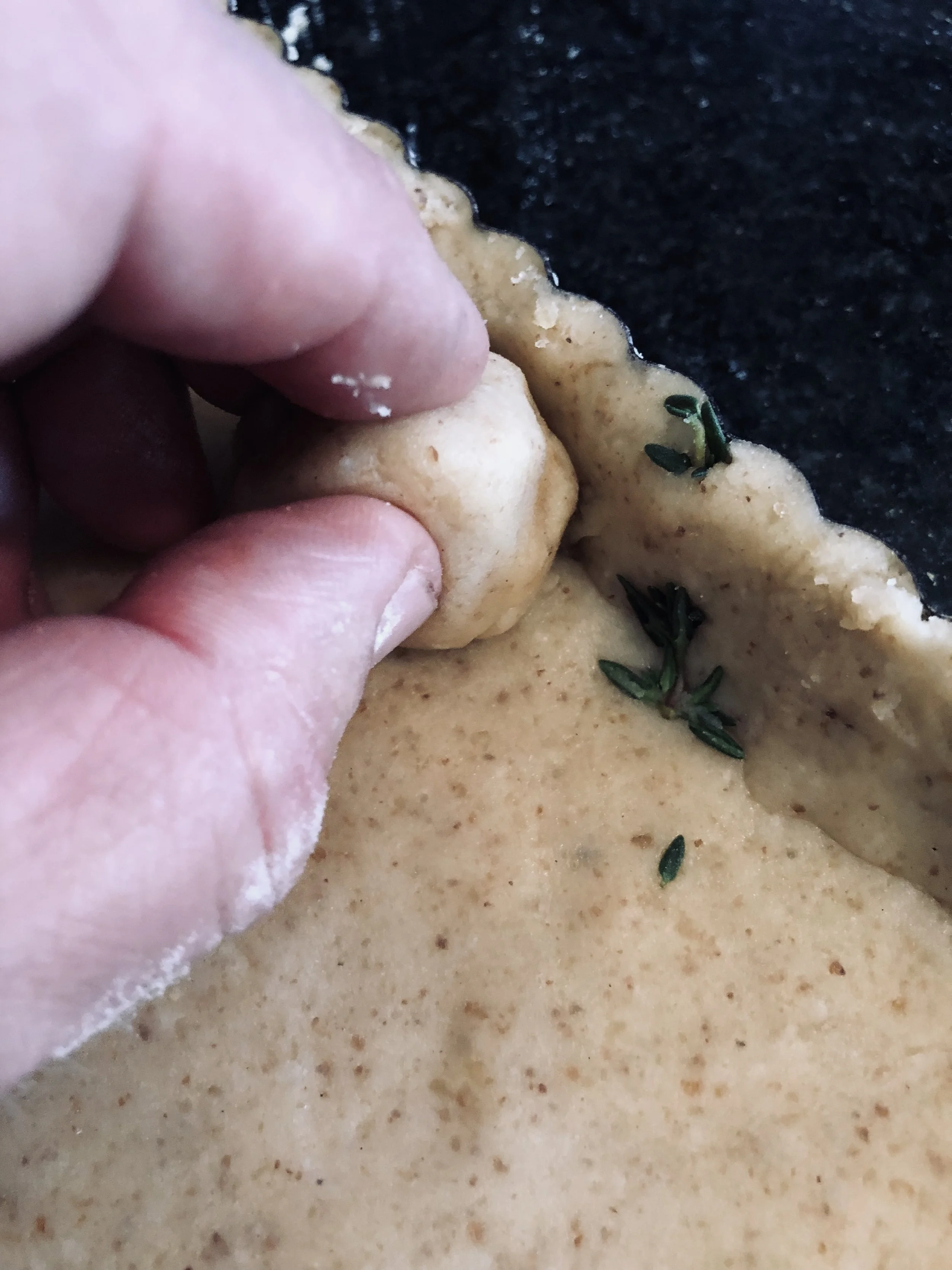 Ball up a scrap piece of the pastry dough to help “push” into the corners and fluted sides of the tart pan.
