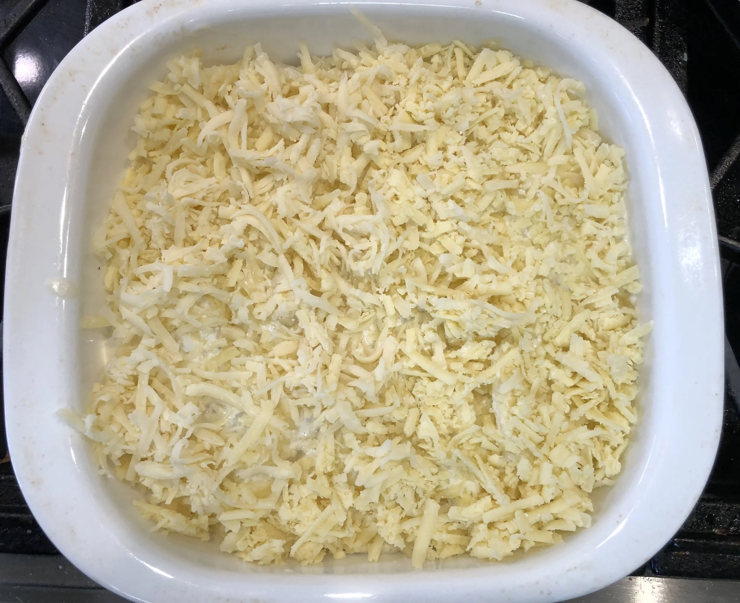 Top with the shredded cheese before baking
