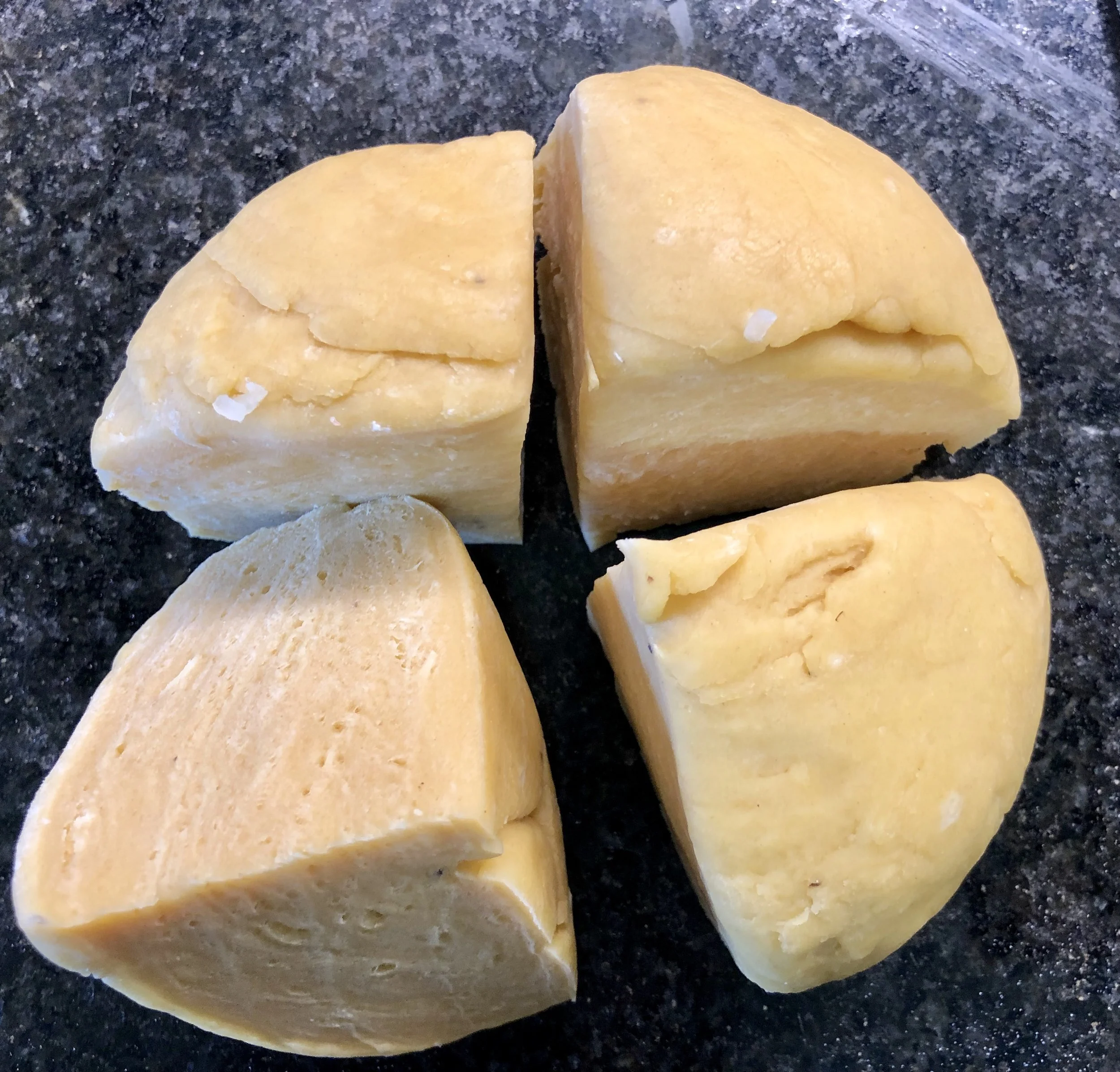 Once the dough is made and rested, quarter it for rolling the ravioli sheets.