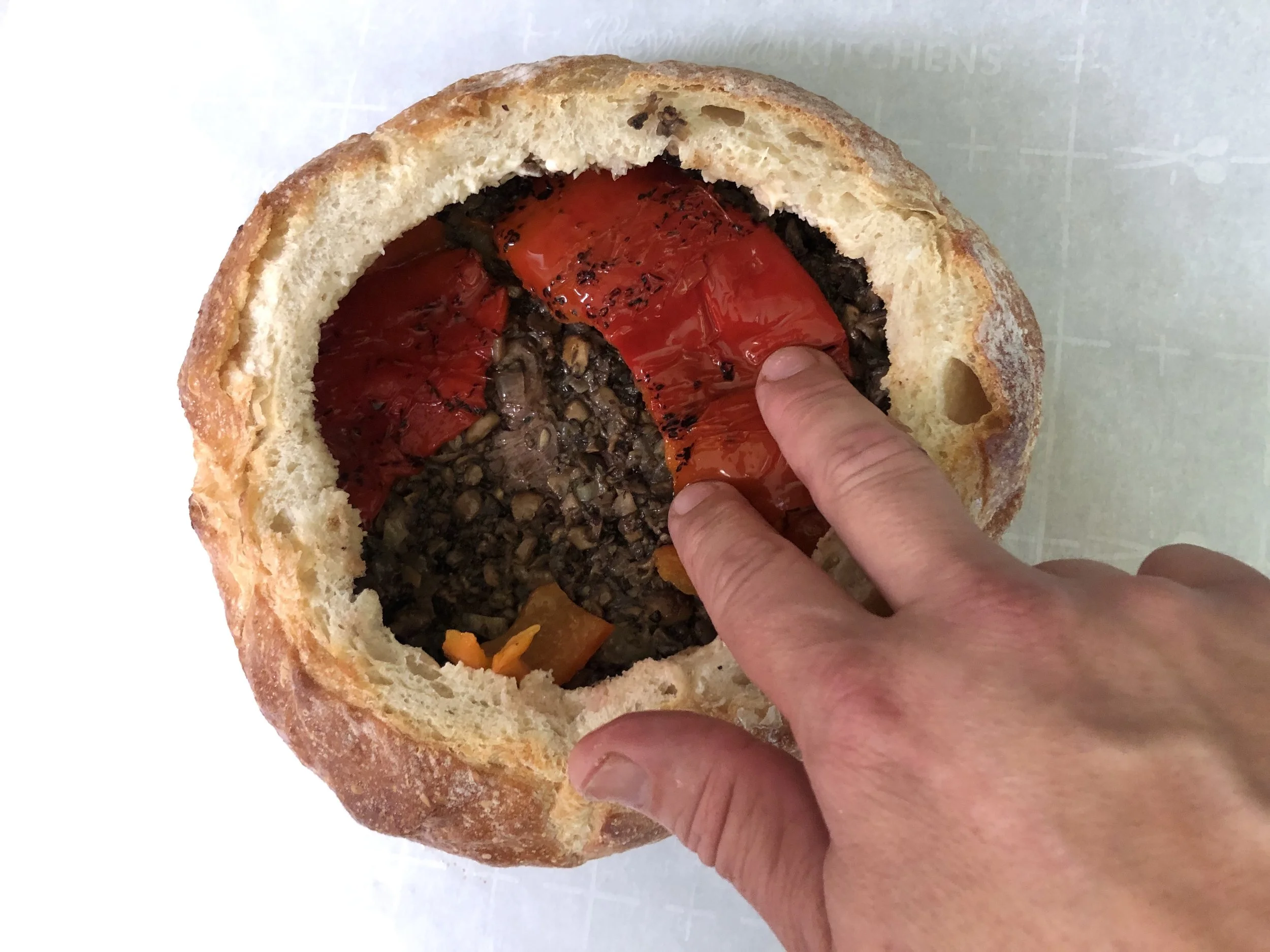 Layer in the steak, duxelles, then roasted red bell pepper, making sure to cover the entire diameter of the bread bowl.