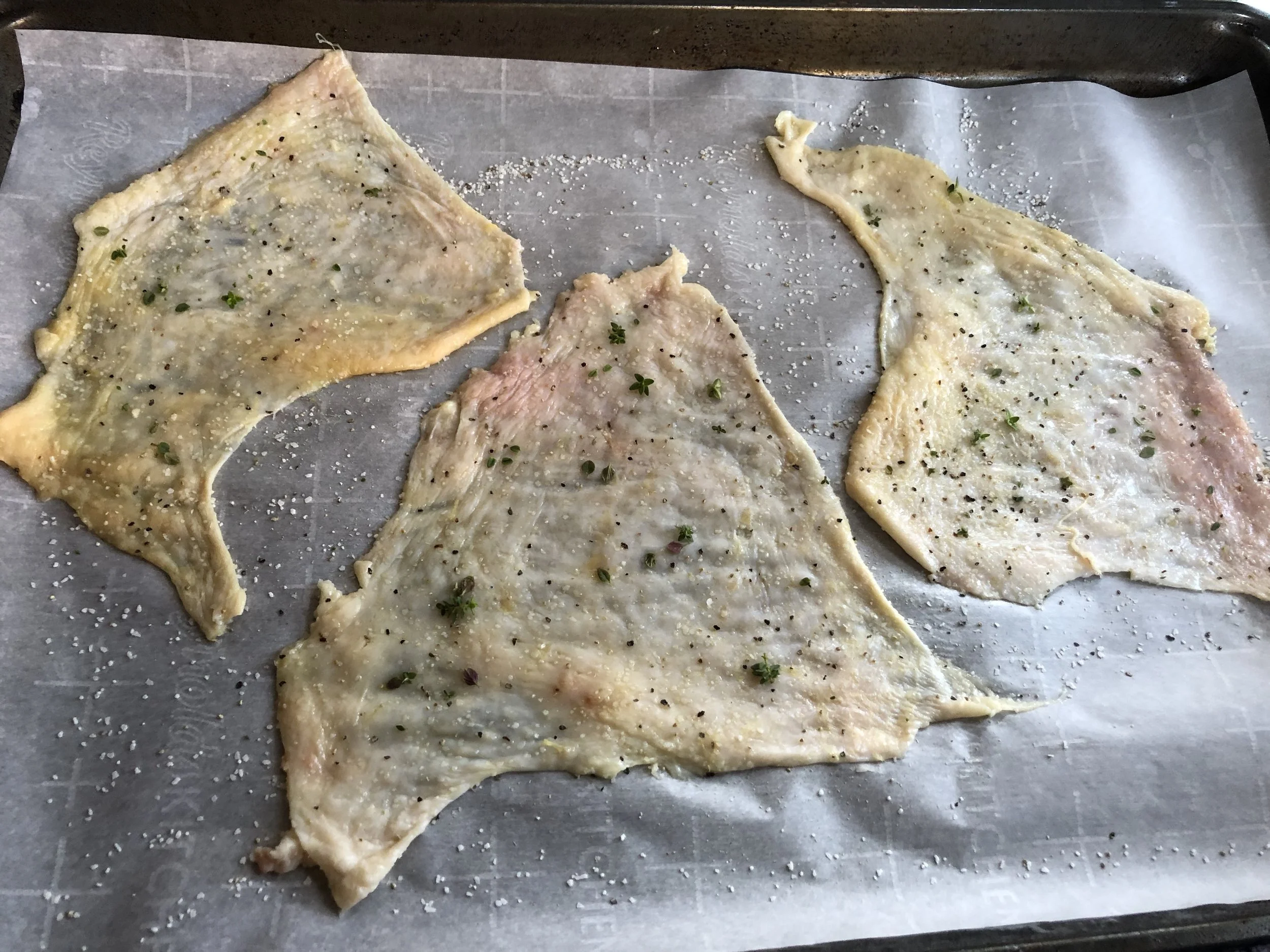 Lay the whole skin pieces out on a lined pan. Season, cover, stack, and bake.