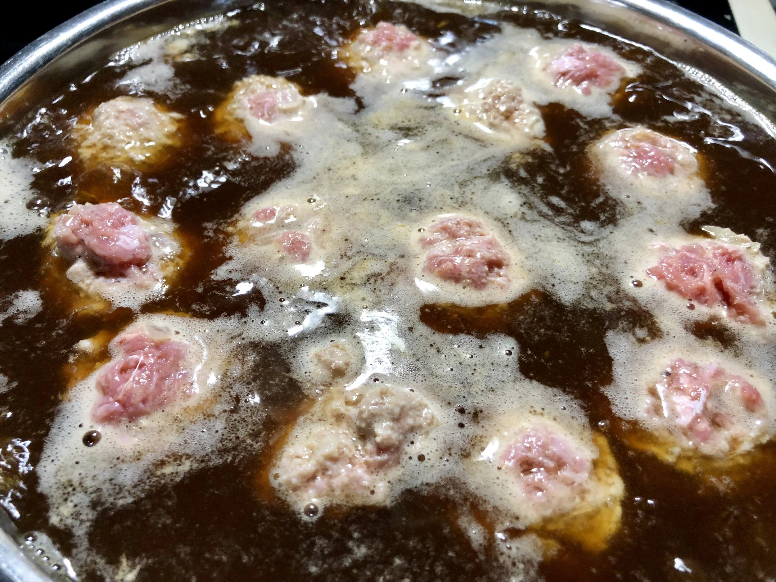 Drop the meatballs into boiling beef stock.