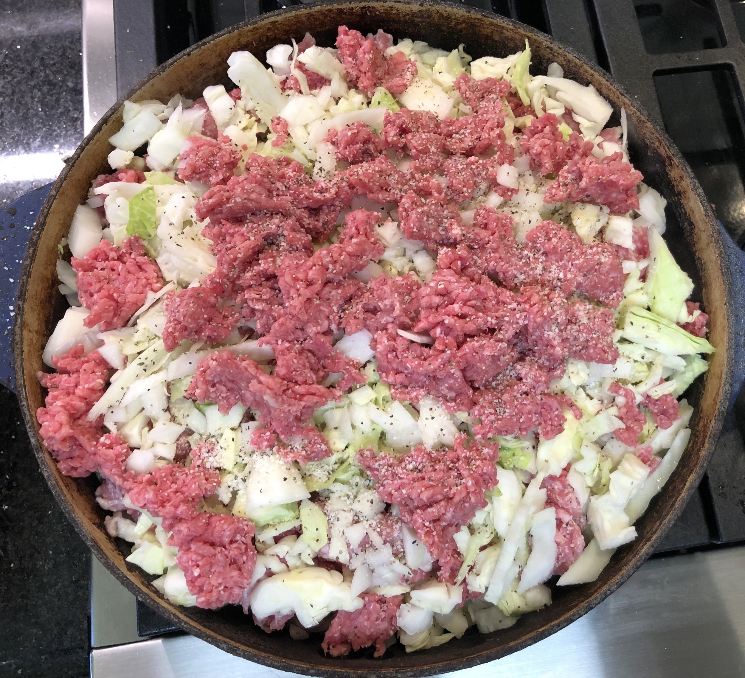 Layering the cabbage, onion, and meat to slowly braise.