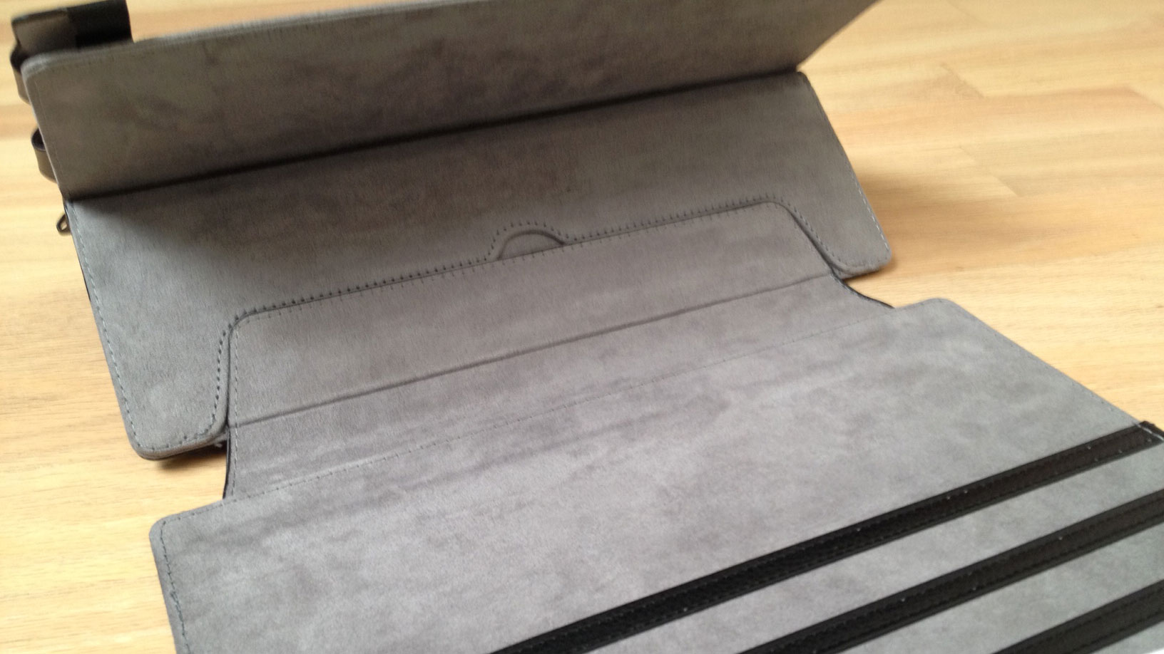 Both covers adhere to the frame with a wide velcro tab. The flap on the frame folds out to provide great stability when the case is opened. The Surface Pro sits much more firmly in one's lap when used in this manner (see gif animation below).
