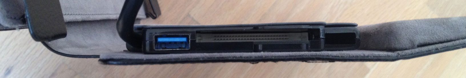 The connecting cable hides a USB 3.0 and CF card reader on the left side of the dock cover. The vacant cable storage port is to the right of the card reader.
