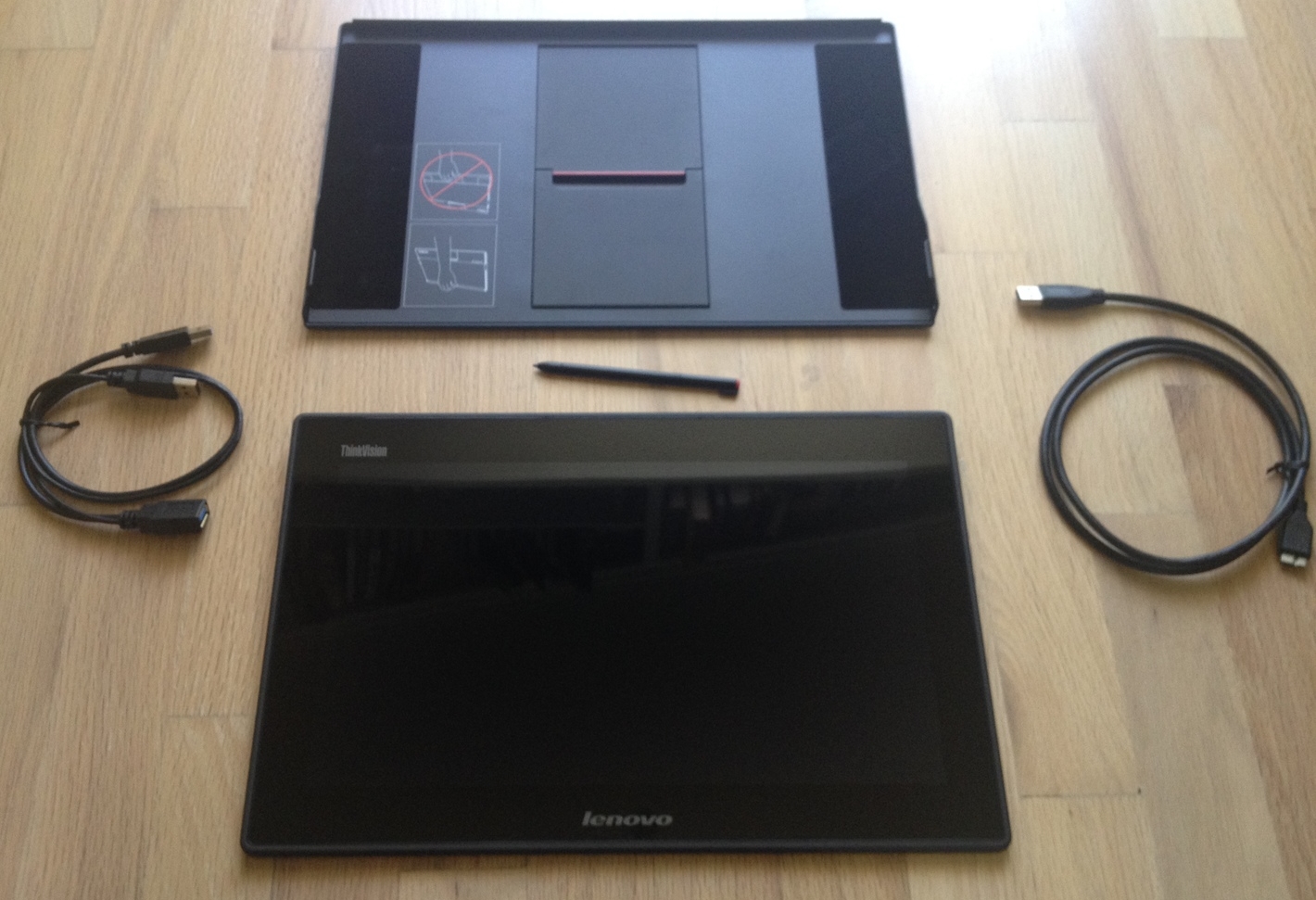 The ThinkVision USB monitor comes with the cover stand (top), USB 3.0 micro-B to USB 3.0 cable (right), a USB 3.0 Y cable (left) and the Lenovo pen, which can be siloed in the upper right corner of the monitor.