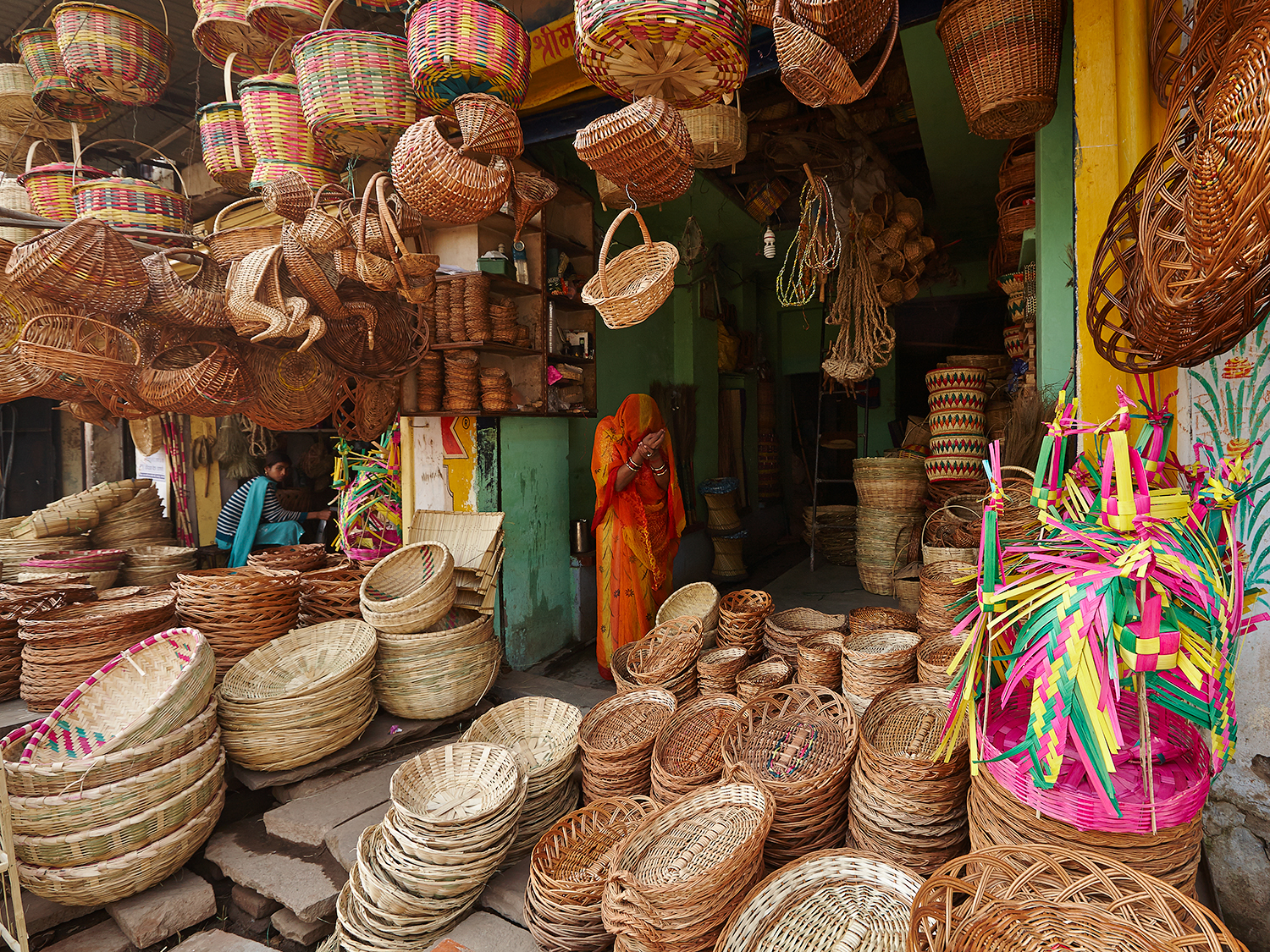 A Basket Seller offers morning prayers while opening her shop in the early morning