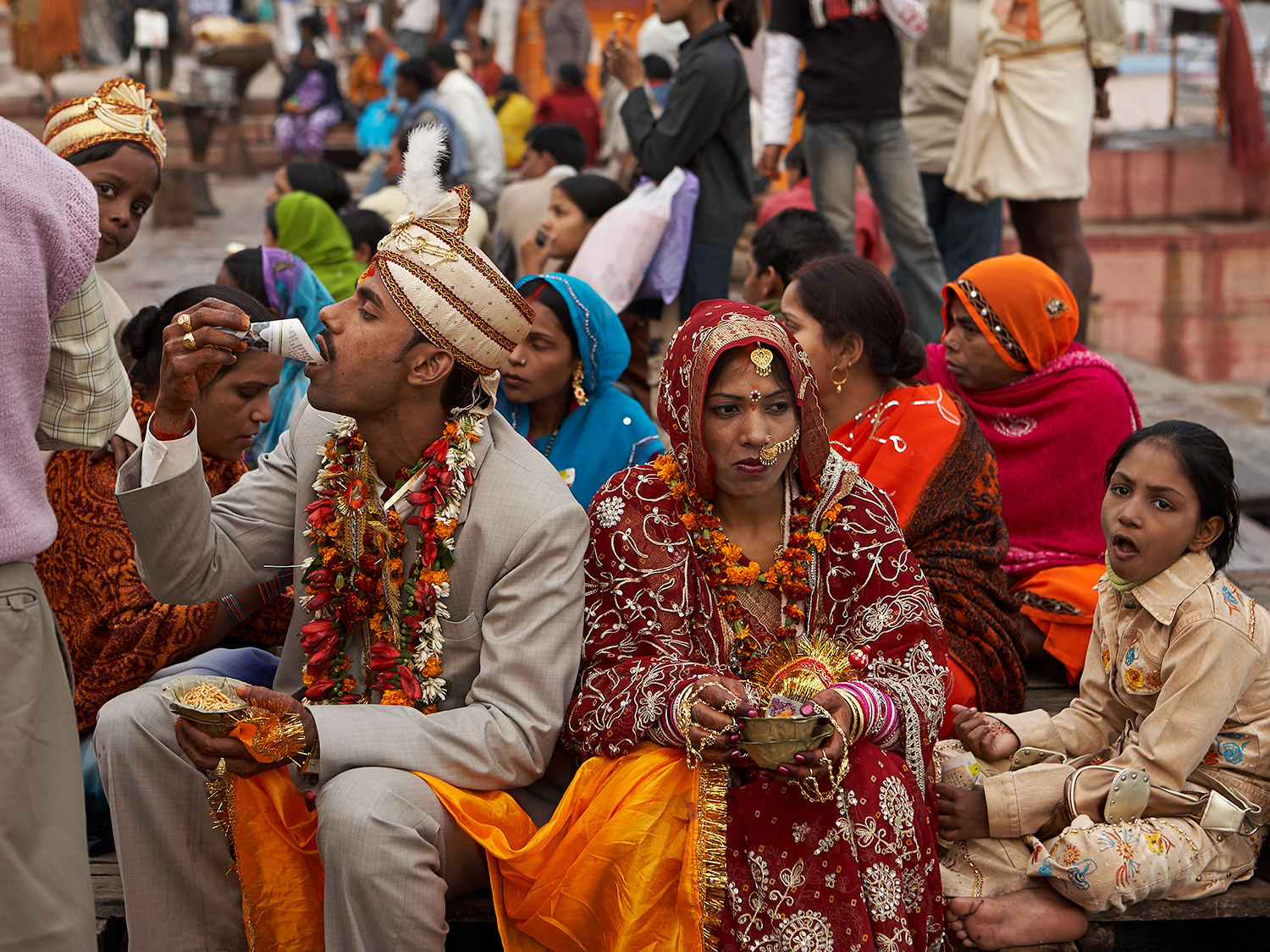 A newly-wed couple, their best man and best lady, sitting on Dashaswamedh Ghat and enjoying light snacks.