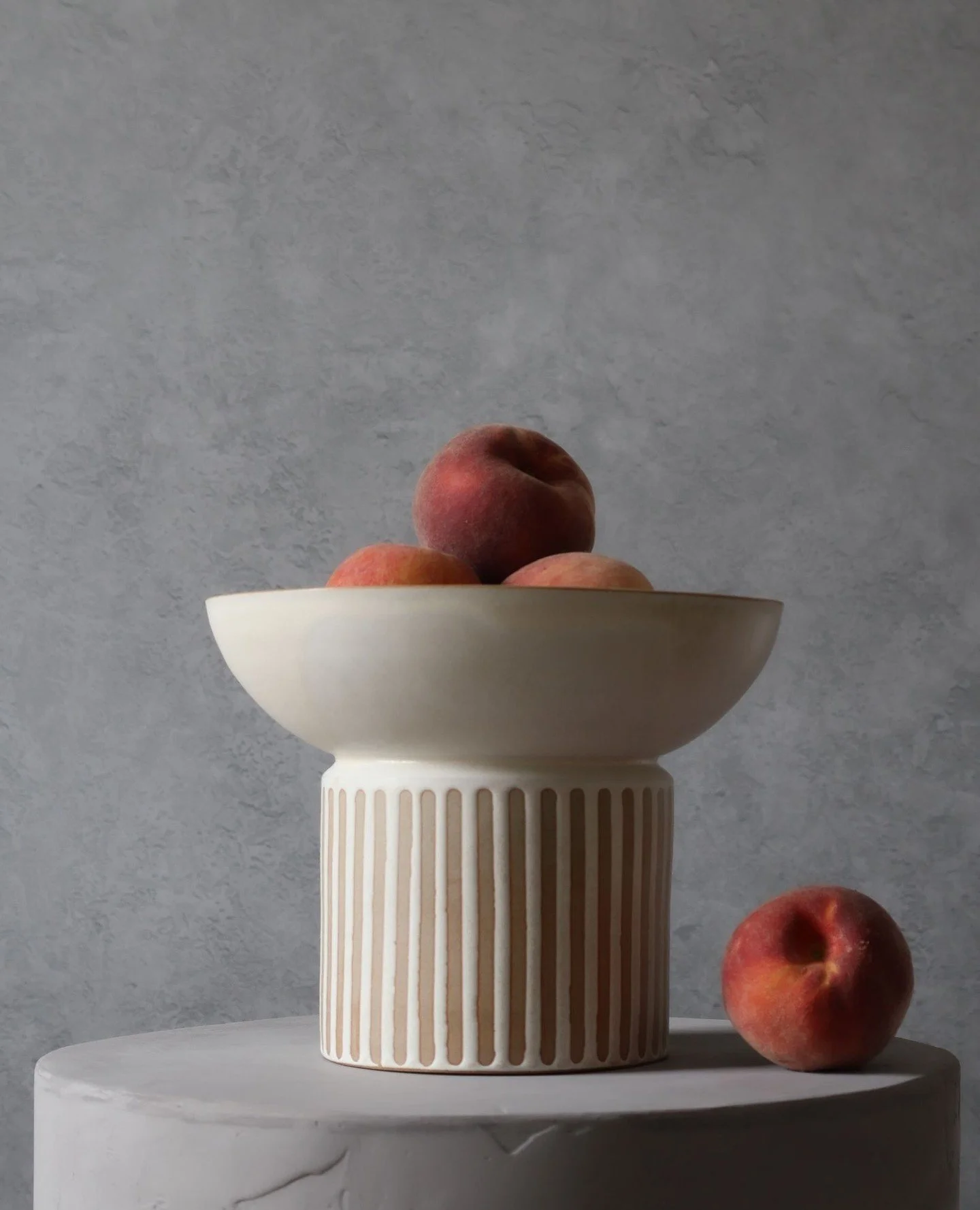 Heavy-footed. Light-touched.⁠
⁠
This one&rsquo;s a prototype&mdash;testing form, proportion, and the weight of a low-slung bowl on a wide, solid pedestal. In the first image, there are some of the first peaches I've seen at the market this year &mdas