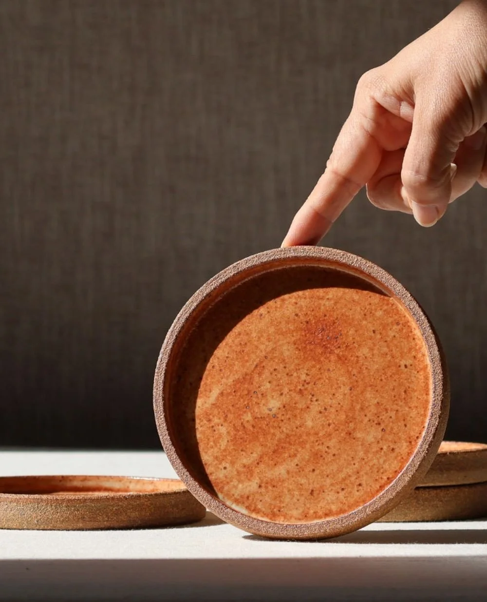 Fire and stone. 🪨🔥
⁠
These surfaces carry stone, glass, rust, iron, and ember cooled into form. Each piece is grounded by lightly sanded stoneware exterior. ⁠Compact and versatile, they serve as coasters or small plates for salt, sweets, or amuse-b