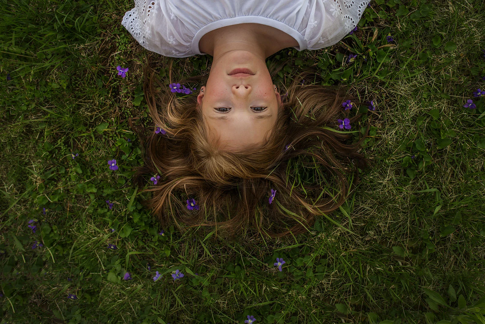 girl laying in grass with purple flowers by kellie bieser web version.jpg