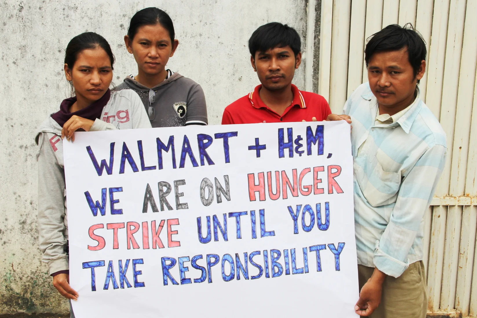 Hundreds of Phnom Penh workers camped outside their shuttered garment factory to demand Walmart and H&M pay them the wages they are owed.