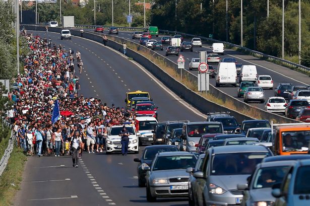 Refugees begin a slow march to Austria from Budapest after trains and police made things difficult for them.