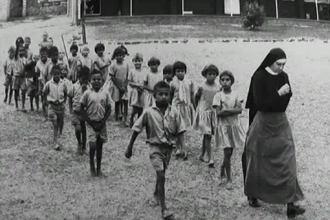A nun leads aboriginal children away