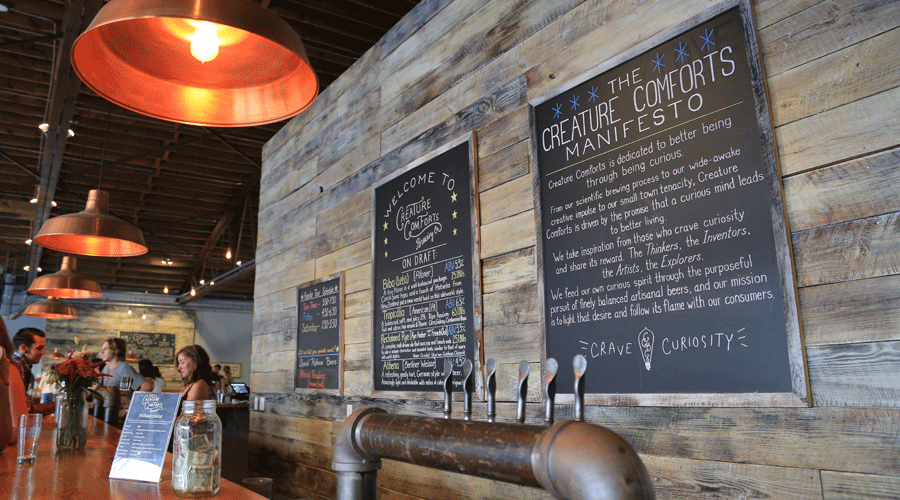 The reclaimed wood interior of Creature Comforts Brewery is one of the brand’s visual tropes.