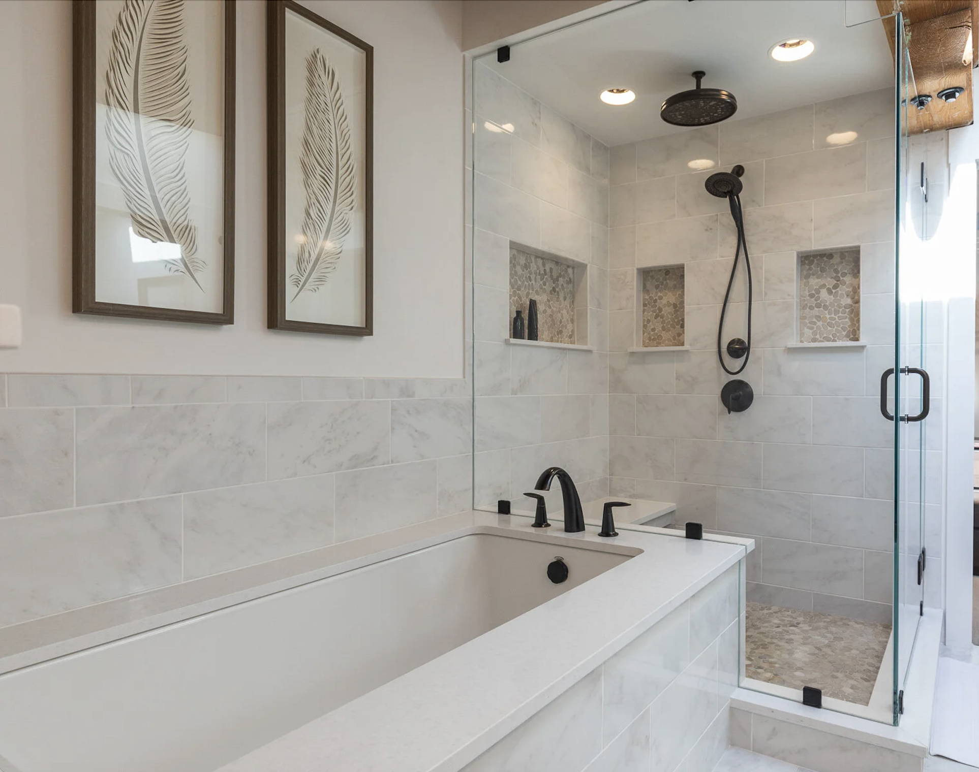 Luxury bathroom featuring a built-in soaking tub, glass-enclosed shower with black fixtures, marble tile walls, and recessed shower niches