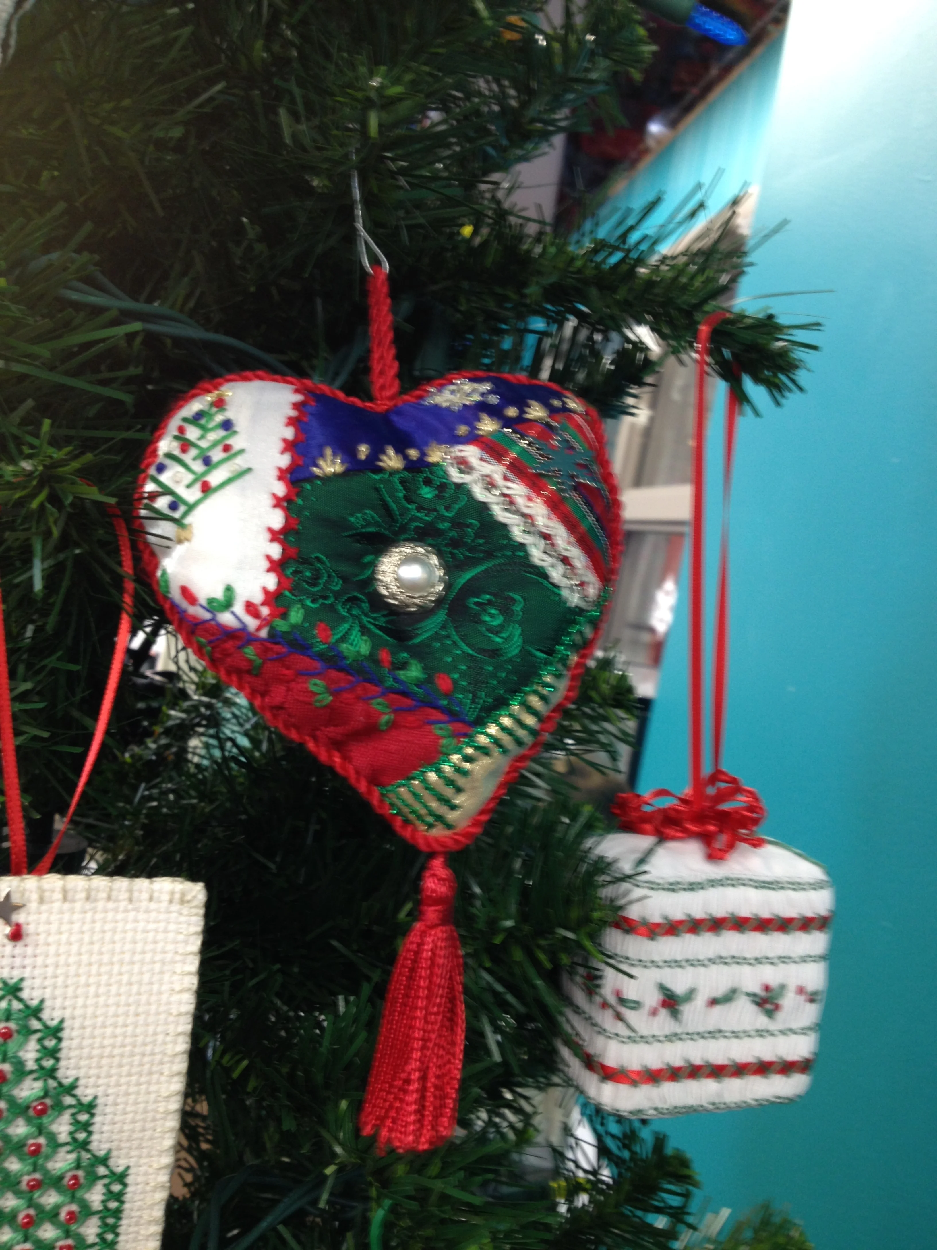 a crazy quilted ornament with twined piping and tassel